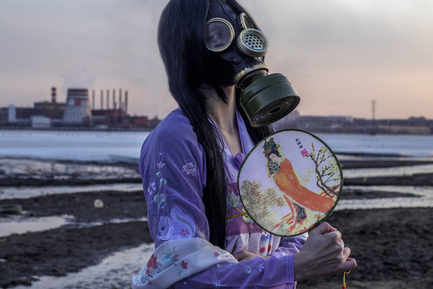 Concepto de cuarentena por coronavirus. Una niña con un vestido nacional coreano y máscara de gas durante el covidio-19 coronavirus alerta pandémica mundial y peligro. Problema ecológico
 - Foto, Imagen