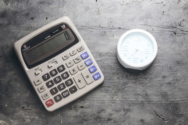 сірий великий калькулятор і будильник, що показує 7 годин
  - Фото, зображення