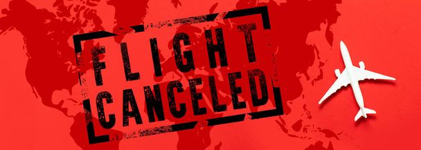 Flights canceled banner with world map and airplane model on red background. Coronavirus Pandemic, Covid 19 - Photo, Image