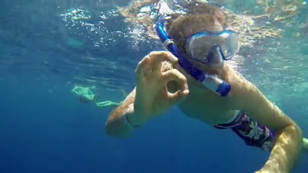 Homem com equipamento de mergulho que gosta de nadar na água do mar
 - Filmagem, Vídeo