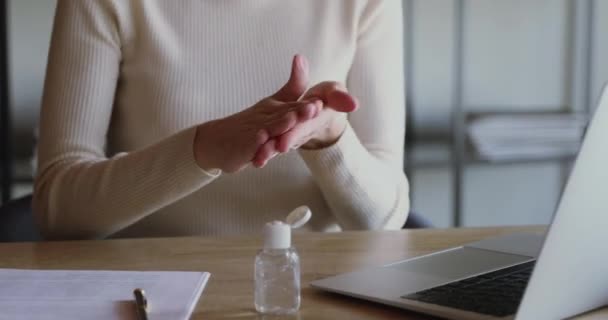 Young woman applying sanitizer rubbing hands before distance computer work - Imágenes, Vídeo
