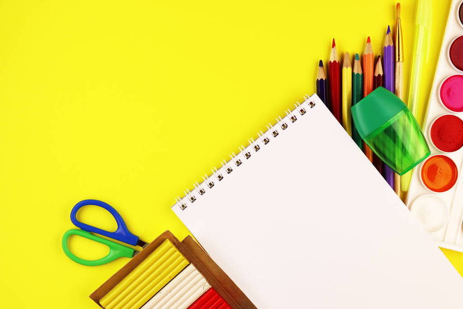 School stationery on a yellow background, top view. paint, Notepad, and colored pencils - Foto, imagen