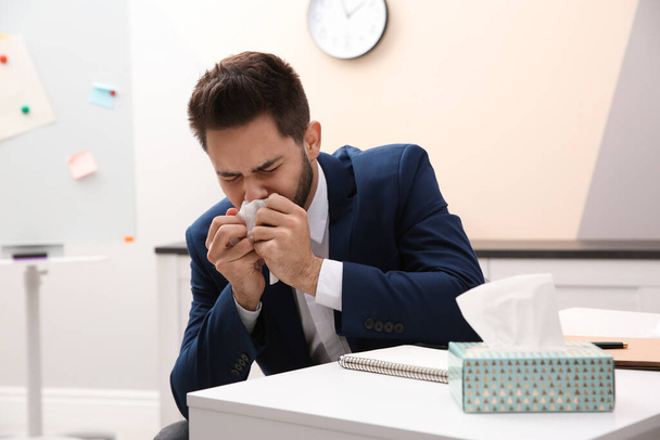 Sick young man at workplace. Influenza virus - Фото, зображення