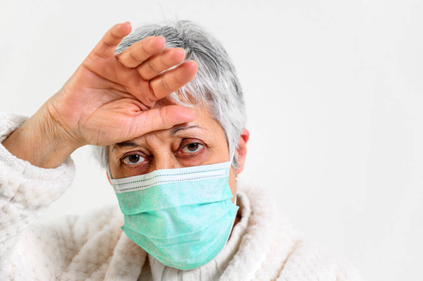 Covid-19. Portrait de femme âgée malade, portant un masque de protection du visage, fièvre et toux, pneumonie, patient à risque, grippe et rhume
. - Photo, image