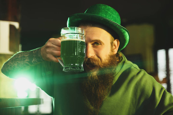 Man with glass of green beer in pub. St. Patrick's Day celebration - Zdjęcie, obraz