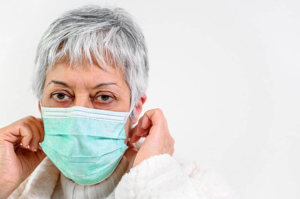 Covid-19. Senior woman portrait, wearing face protection mask, risk patient, protection against coronavirus flu and cold. - Photo, Image