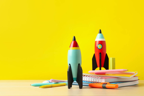 Bright toy rockets and school supplies on wooden table. Space for text - Фото, зображення