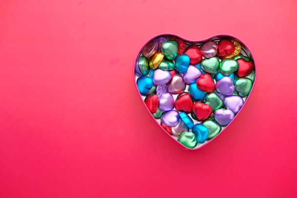 vue du dessus du chocolat dans une boîte en forme de coeur en arrière-plan rouge
  - Photo, image