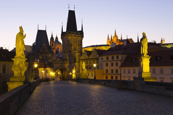 Bunte Prager gotische Burg mit Nikolaikathedrale und Brückenturm von der Karlsbrücke mit ihren barocken Statuen ohne Menschen zur Zeit des Coronavirus, Tschechien - Foto, Bild