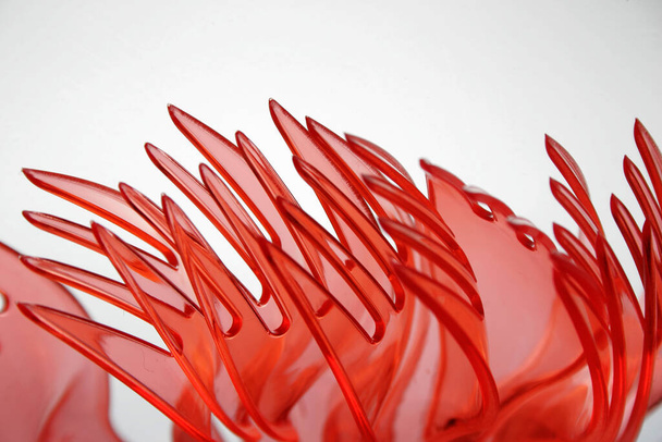 Rood doorschijnende plastic vorken op een witte achtergrond - Foto, afbeelding