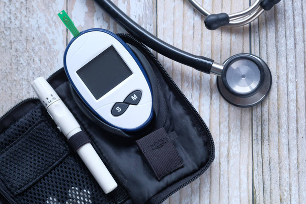  diabeteksen ja stetoskoopin verensokerin mittaus pöydällä
  - Valokuva, kuva