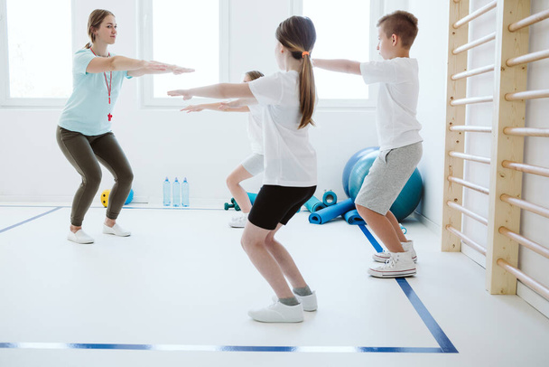 Kids exercising during physical education at school gym - Фото, зображення