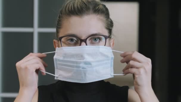 Girl, woman does not wear a medical protective mask correctly, looks at the camera. Coronavirus quarantine concept. The woman is locked. Quarantine. face mask - Séquence, vidéo