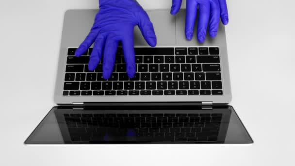 Using laptop computer with medical gloves to protect against coronavirus covid-19, doctor entering patient information - Video, Çekim