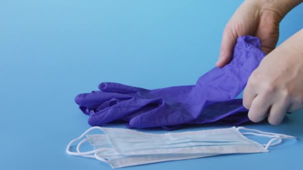 Doctors and nurses taking medical latex gloves and protective respiratory masks on blue background, 4k - Video