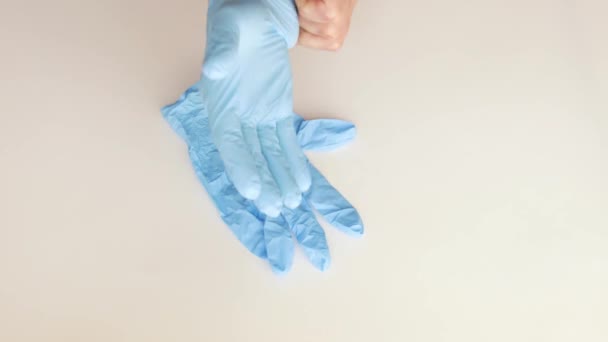 Doctor putting on protective blue medical latex gloves, close-up from above, 4k - Záběry, video