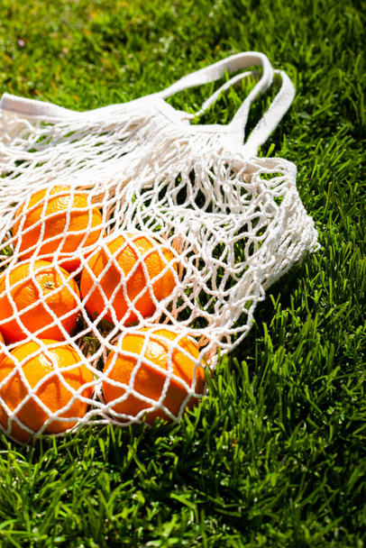 Eco String Bag with Oranges On Grass. - Photo, image