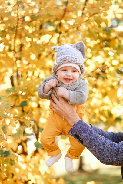 a young son is held by his father during a nature walk in the fall - Foto, Imagen