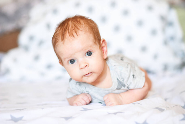Cute happy 7 month old boy is lying in his crib - Zdjęcie, obraz