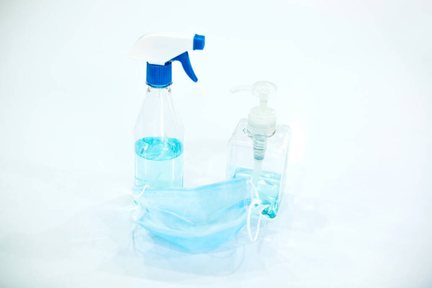 Σπρέι για αλκοόλ με ιατρική προστατευτική μάσκα σε λευκό φόντο, Prevent Coronavirus, παράγοντας προστασίας για τον ιό Coronavirus Covid 19. - Φωτογραφία, εικόνα