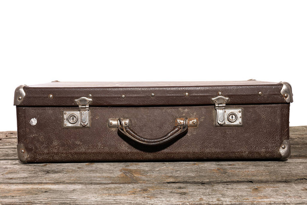 Vieille valise marron pour les lys de voyage sur la table en bois
 - Photo, image