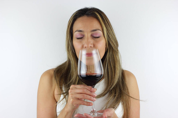 Kaunis kolumbialainen nainen haistaa viiniä
 - Valokuva, kuva