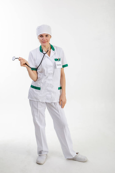 Doutor em um manto branco com um estetoscópio em suas mãos
 - Foto, Imagem