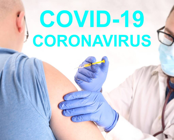 Coronavirus rokote. Lääkintämies kasvonaamiossa ja siniset suojakäsineet rokottamassa miestä. Ennaltaehkäisevät rokotukset virustauteja vastaan. Sepelvaltimotautipandemian pysäyttäminen
 - Valokuva, kuva