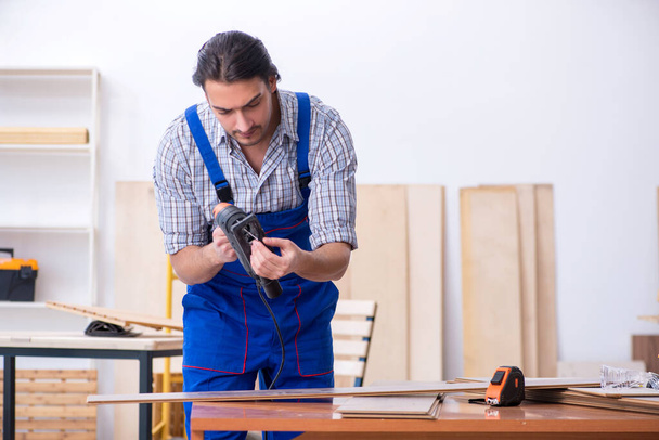 Joven carpintero masculino trabajando en interiores - Foto, imagen