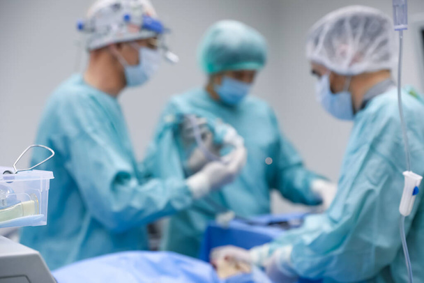 Blurred view of doctors operating patient in surgery room - Foto, immagini