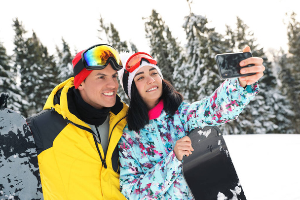 Couple taking selfie on snowy hill. Winter vacation - Foto, imagen