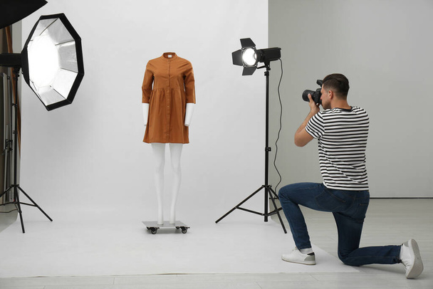 Professional photographer taking picture of ghost mannequin with stylish clothes in modern photo  - Foto, afbeelding