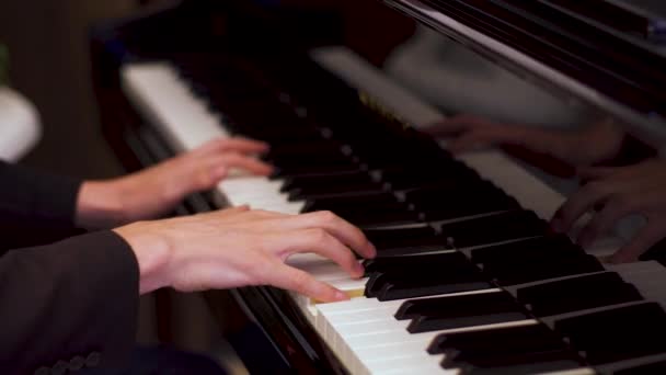 Giovane caucasico suona la composizione classica su un pianoforte in un ristorante di hotel di lusso
. - Filmati, video