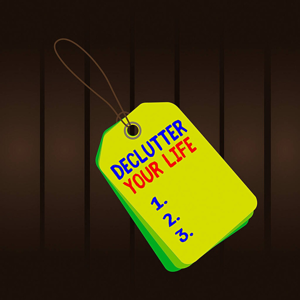 Writing note showing Declutter Your Life. Business photo showcasing To eliminate extraneous things or information in life Rectangle badge attached string colorful background with tag. - Photo, Image