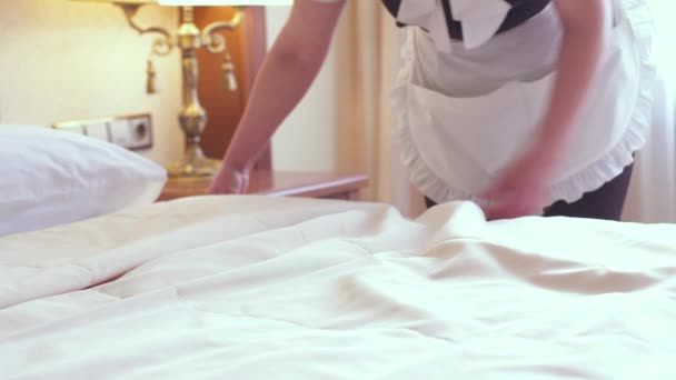Een meid maakt een bed op in een luxe hotelkamer. Geweldige Engelse dienst. - Video