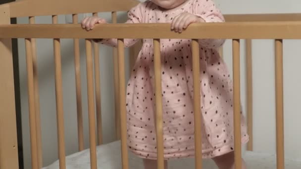 Little child is a cheerful girl in a baby chair. - Video