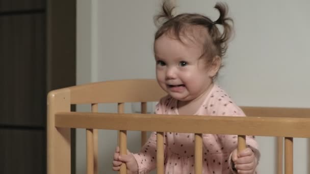 Little child is a cheerful girl in a baby chair. - Materiał filmowy, wideo