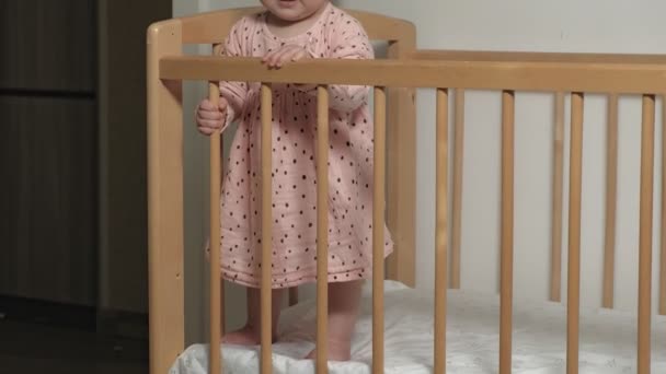 Little child is a cheerful girl in a baby chair. - Imágenes, Vídeo