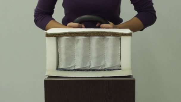 Mujer pone peso pesado en colchón ortopédico con un coco cámara lenta
 - Imágenes, Vídeo