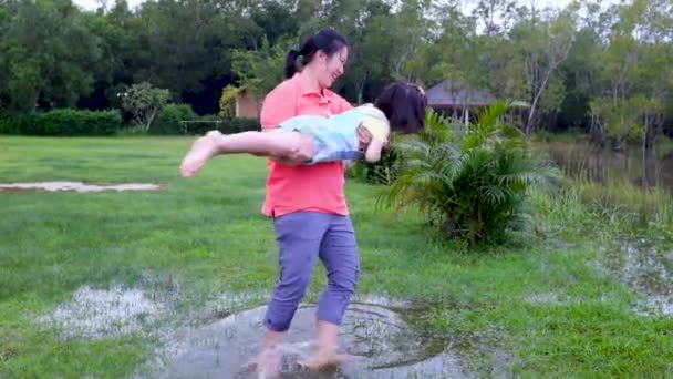 Lassú mozgás. Anya jól érzi magát a gyerekével. Boldog ázsiai lány szórakozik a tónál. Boldog család töltenek időt együtt kívül zöld természet. Utazás nyaralni.  - Felvétel, videó