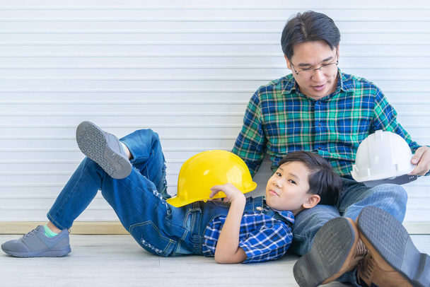 Constructor padre está sentado junto a su hijo para el concepto de conexión familiar en tono vintage
 - Foto, Imagen