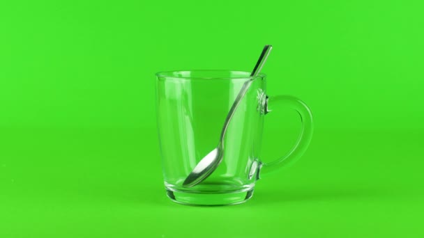 Gießen Sie Zuckerbecher Glas Teelöffel dicken Boden grün kontrastierenden Hintergrundkonzept - Filmmaterial, Video