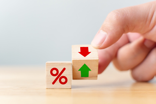 Interest rate financial and mortgage rates concept. Hand flip wood cube change arrow down to up - Photo, Image