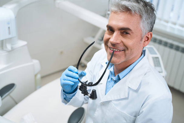 Happy male dentist at workplace stock photo - Фото, зображення