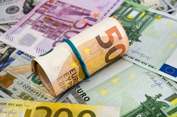 50 euros retorcidos en un rollo sobre un fondo de billetes en euros. Fondo de dinero
. - Foto, imagen