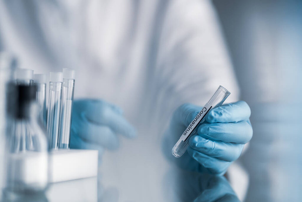 учёный, держащий пластиковую трубку с этикеткой ковида-19 или коронавируса, лабораторные испытания на изобретение пандемических лекарств
 - Фото, изображение