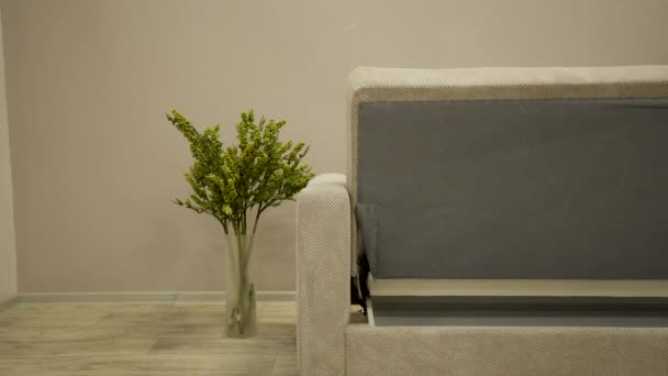 Sofá têxtil branco com cadeira de design e xadrez decorativo se transforma em uma cama
 - Filmagem, Vídeo