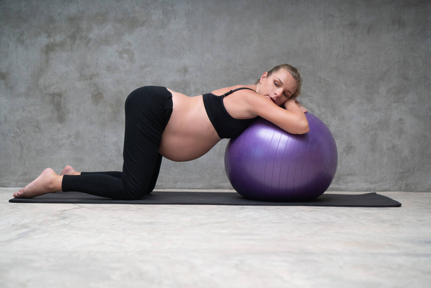 ジムでフィットボールとかなり妊娠中の女性の練習の肖像画。運動とフィットネス、妊娠の概念 - 写真・画像