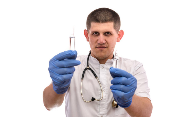 Arzt mit Ampullen. Er trägt Sanitätsuniform und Stethoskop um den Hals - Foto, Bild