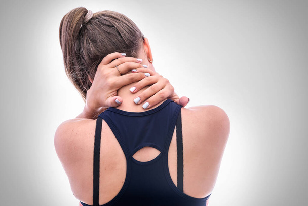 Frau füllt Schmerzen im Nacken von der Rückseite aus. Sie hält dort ihre Hände - Foto, Bild